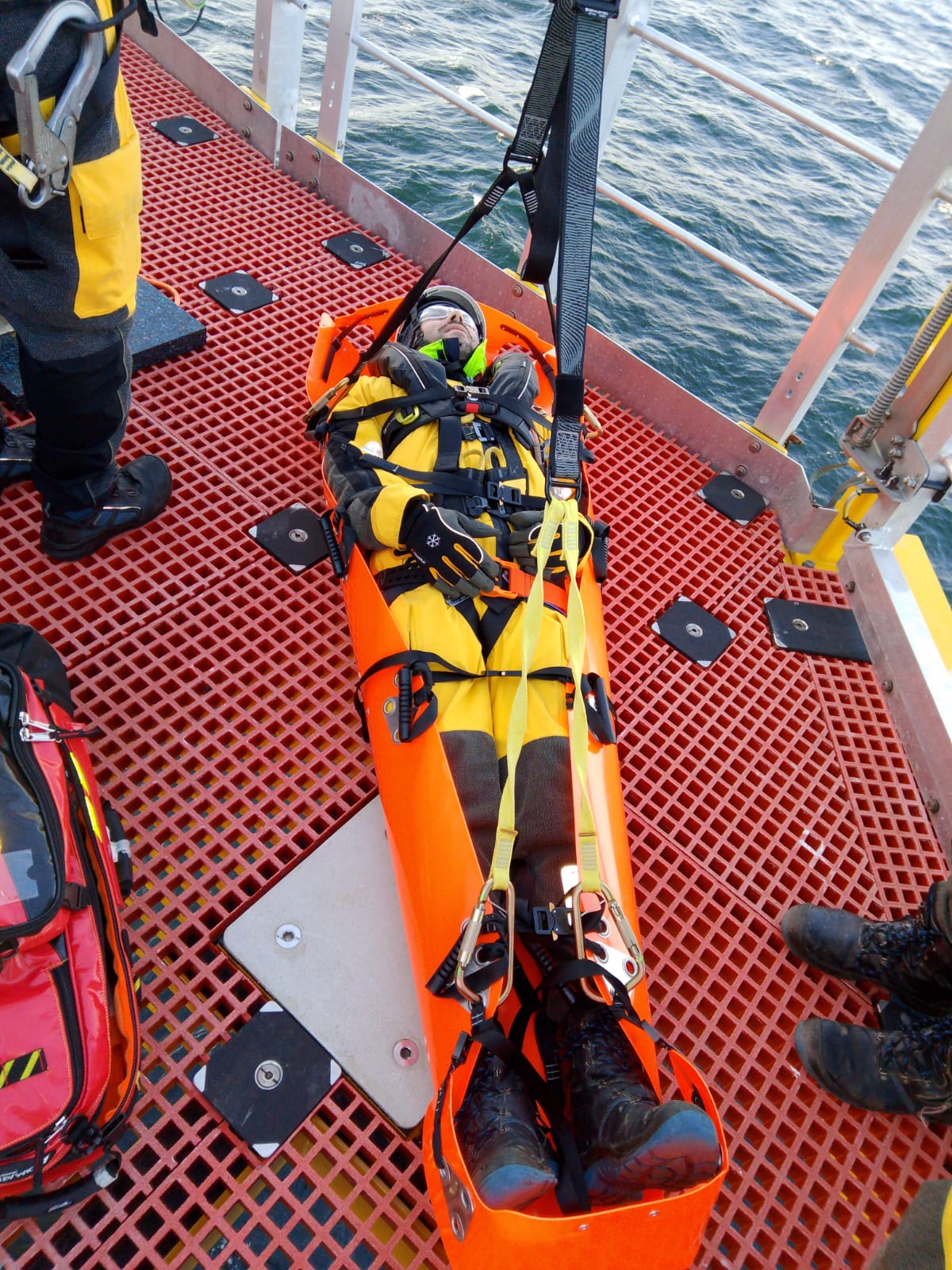 Technician secured in rescue stretcher during offshore safety drill