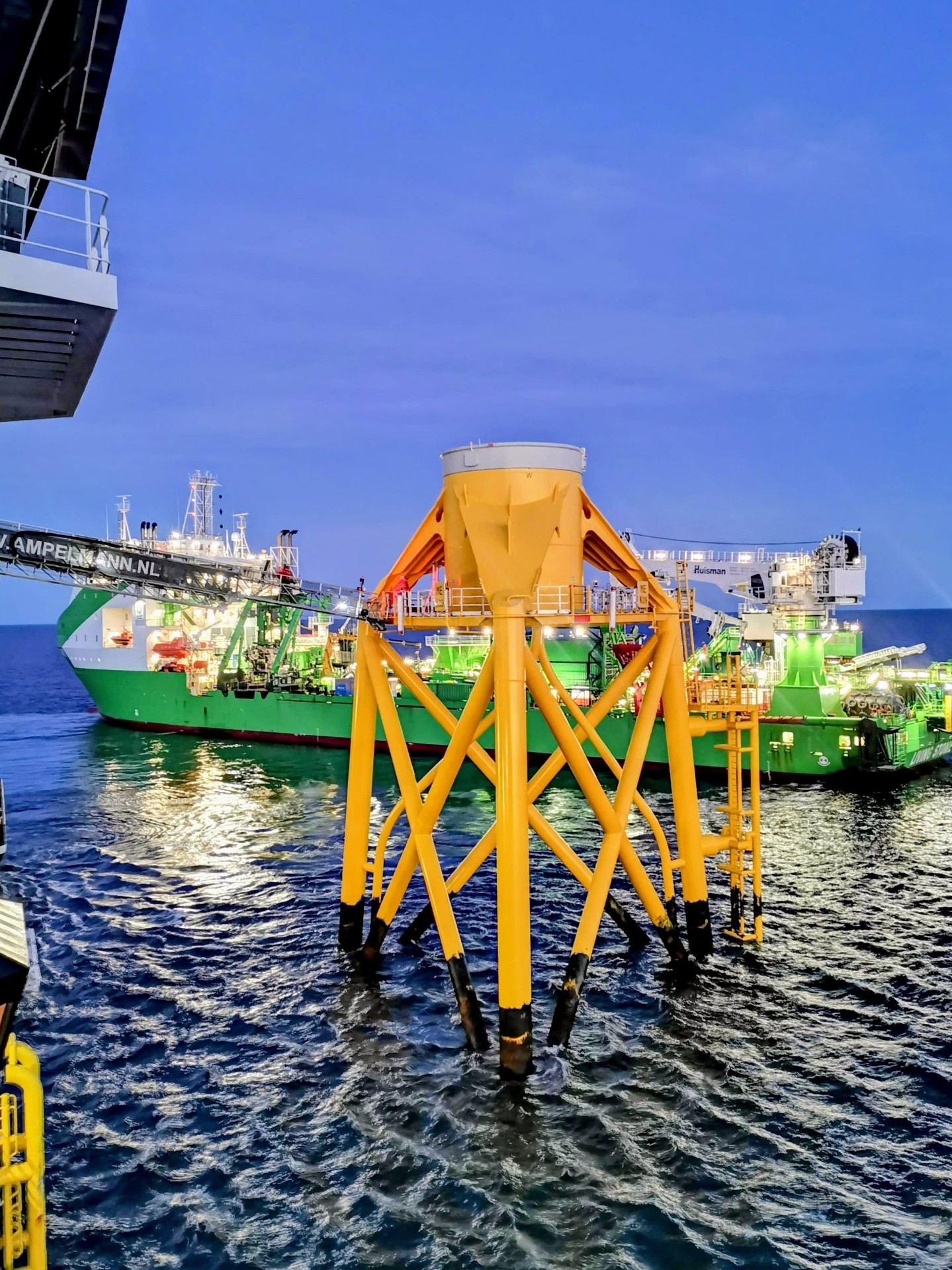 SOV alongside turbine jacket foundation at dusk